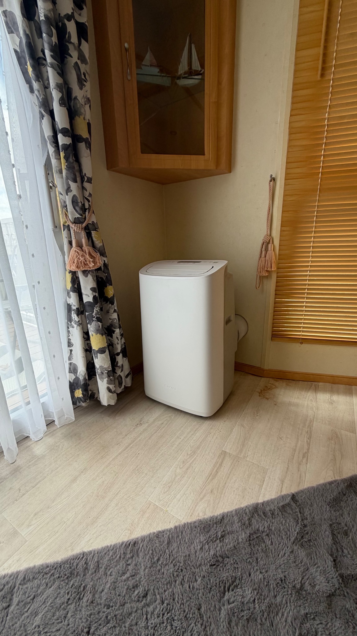 Portable air conditioner installed neatly in the corner of a static caravan