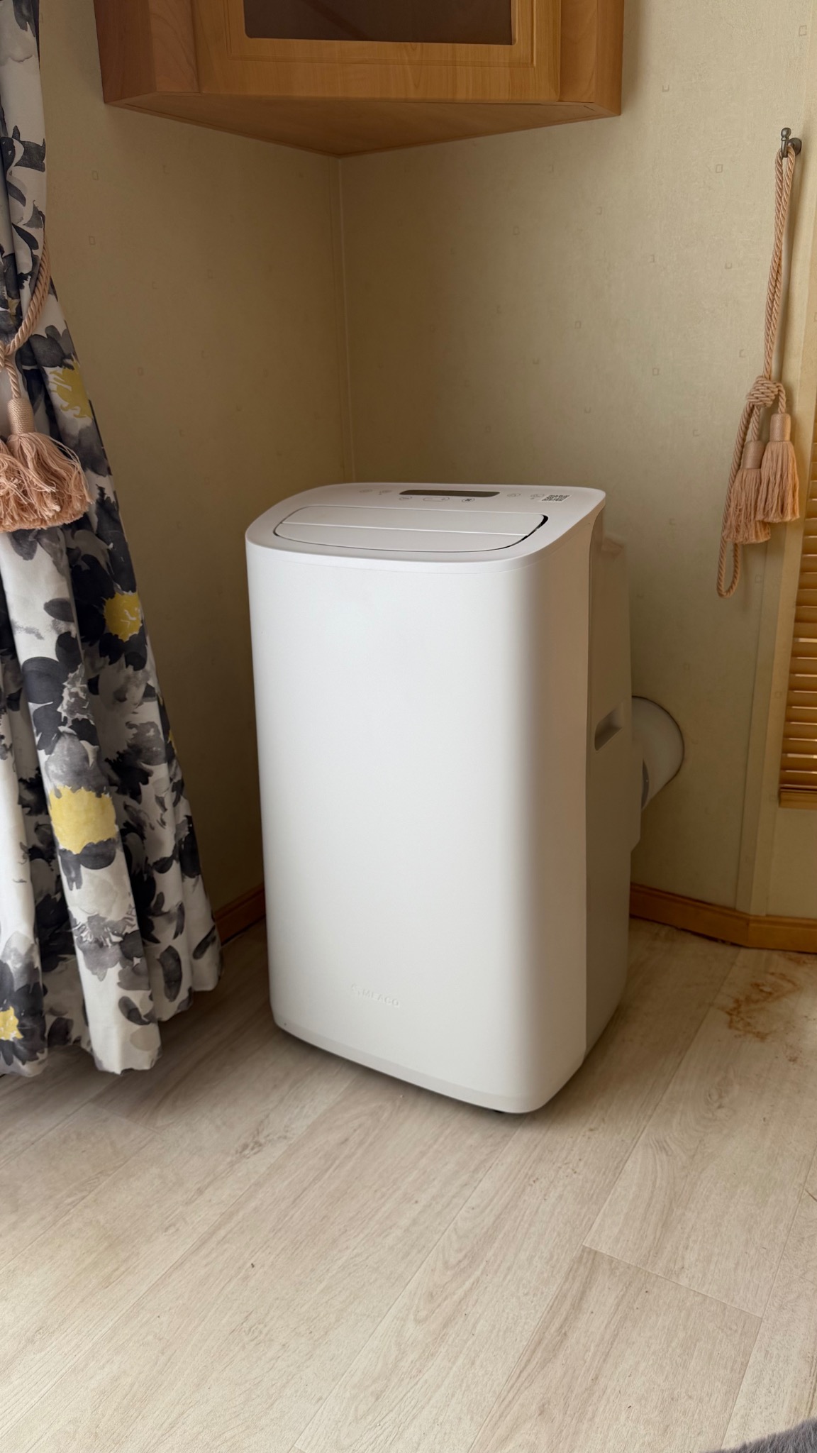 Close view of a portable air conditioner with a dedicated through-wall exhaust outlet