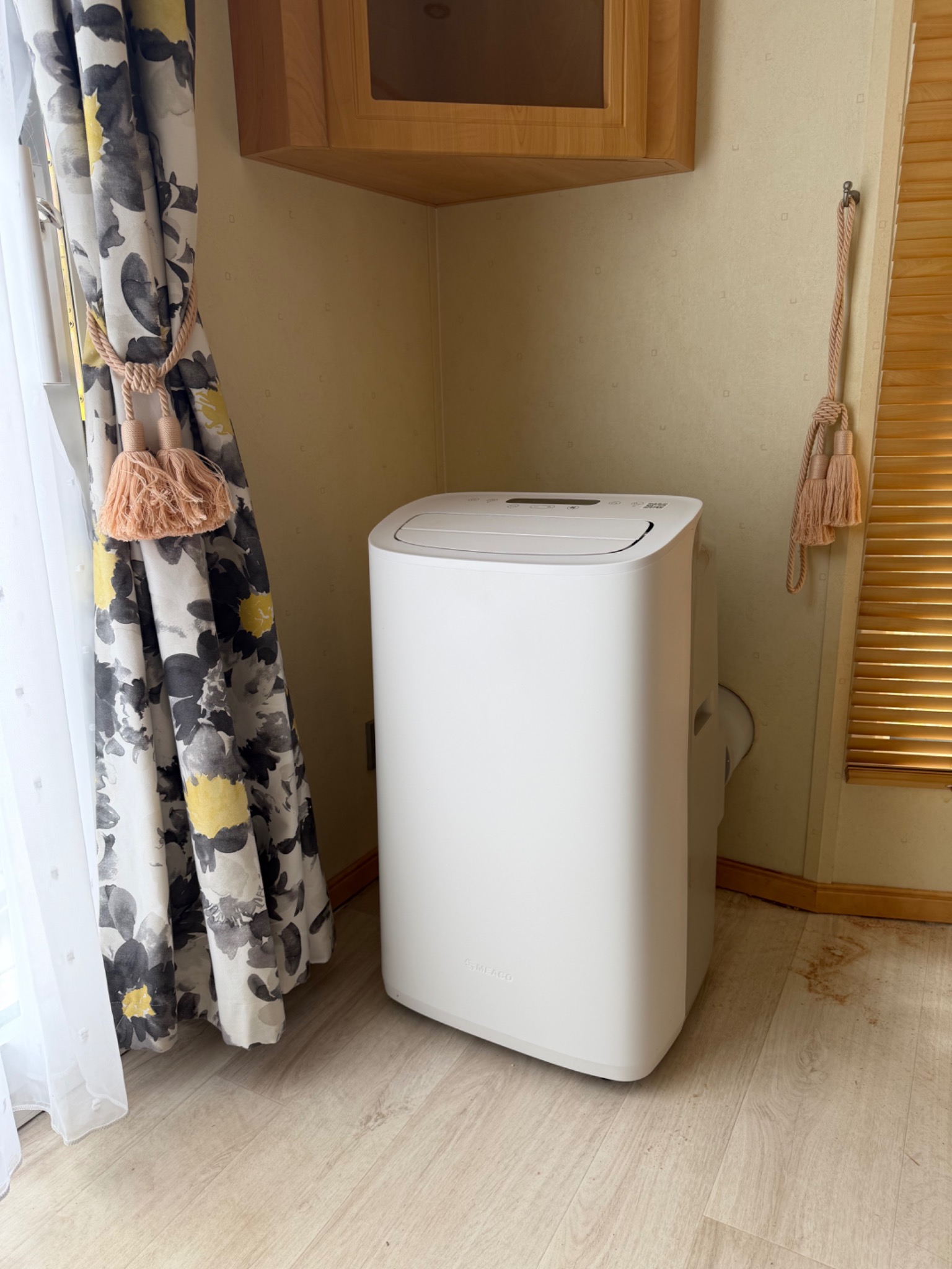 Portable caravan air conditioner with a short exhaust route behind the unit